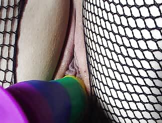 Horny girl in fishnet stockings toys her wet pussy